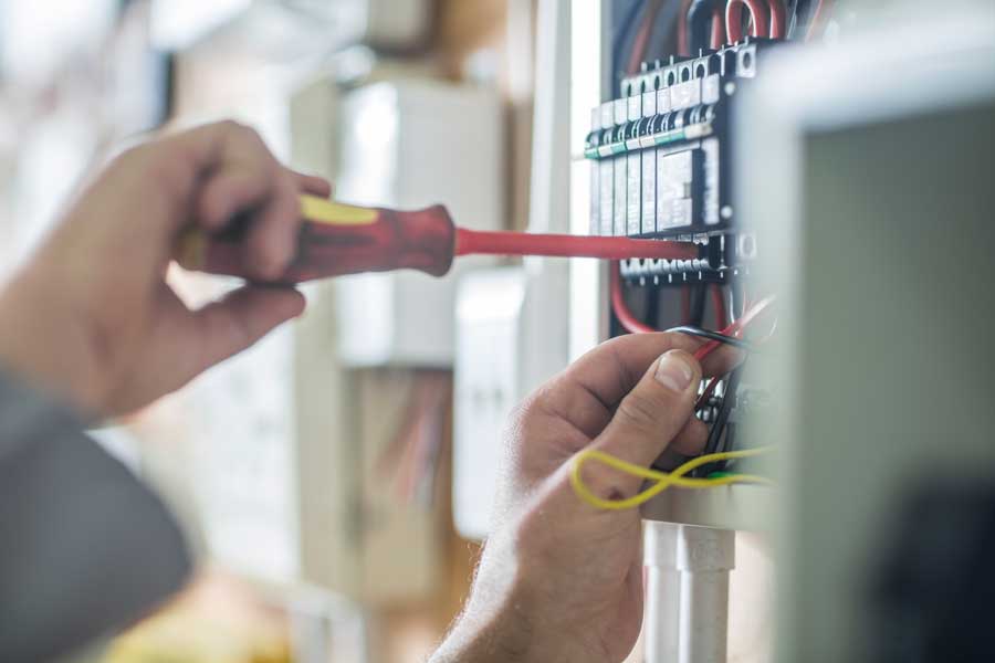 Hand som håller i en skruvmejsel och installerar el